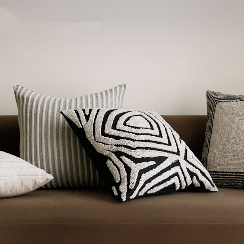 ESSENCE Maze and Pinstripe pillows on a brown sofa